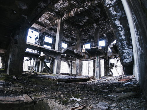 朽ち果てたコンクリート剥き出しの躯体と露出した鉄筋骨組み