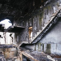 コンクリート躯体が露出した不気味でボロボロの階段と壁の写真