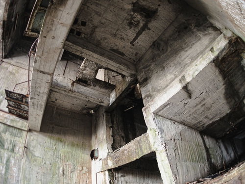 剥がれ落ちたコンクリート躯体が露出した荒廃した建物内部