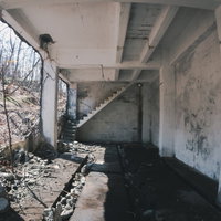 荒廃した白い壁の廃墟の階段と散乱する瓦礫の写真