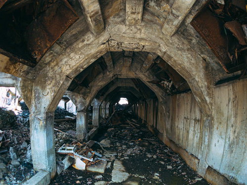 アーチ状の通路に散乱する瓦礫と劣化した躯体