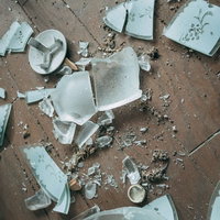 床一面に散乱した粉々のガラス破片と破損の危険の写真