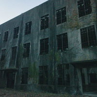 窓ガラスも扉もない廃墟の建物の内部風景と劣化した壁面の写真