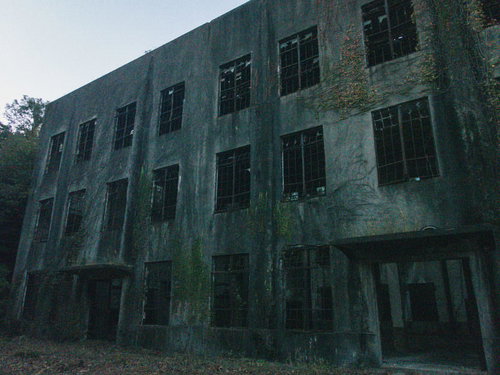 窓ガラスも扉もない廃墟の建物の内部風景と劣化した壁面