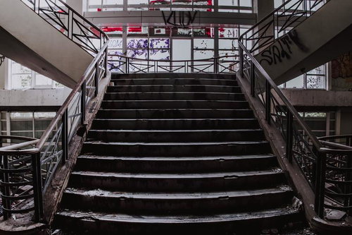廃墟化した商業施設内の錆びついた手すりと朽ちゆく階段