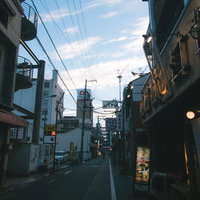 日が落ちてきた商店街の町並み、夜間照明と街灯が点灯する夕暮れの風景の写真