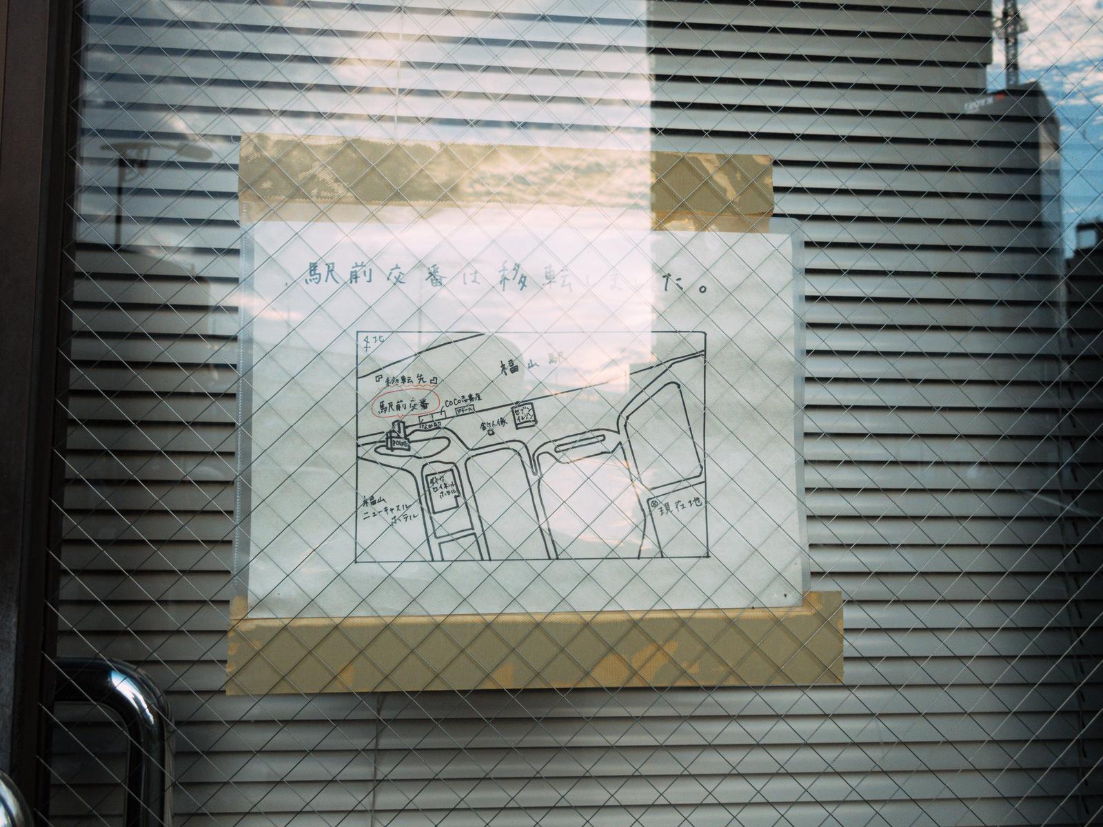 ガムテープで窓に貼られた交番移転の手書き地図
