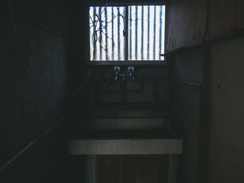 不気味に差し込む洗面化粧台の小窓からの光
