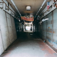 三和市場（尼崎横丁）のシャッターで挟まれた薄暗い通路の写真