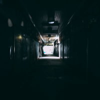 遠くに明かりが見える三和市場の薄暗いアーケードの写真