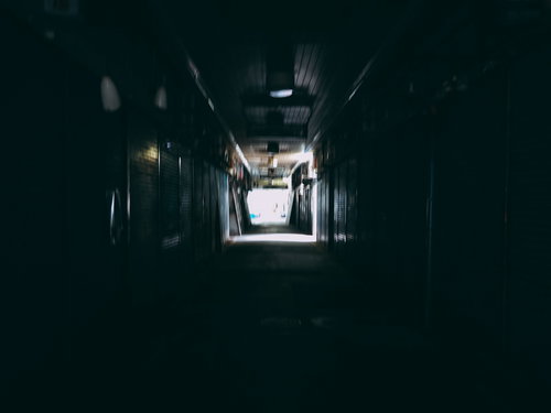 遠くに明かりが見える三和市場の薄暗いアーケード