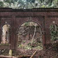 不気味に口を開ける廃発電所のレンガ壁の外観の写真