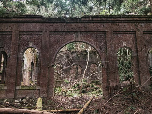 不気味に口を開ける廃発電所のレンガ壁の外観