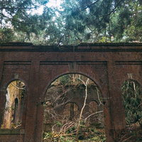 朽ちたレンガ壁が積み重なった廃発電所のアーチ開口部の写真