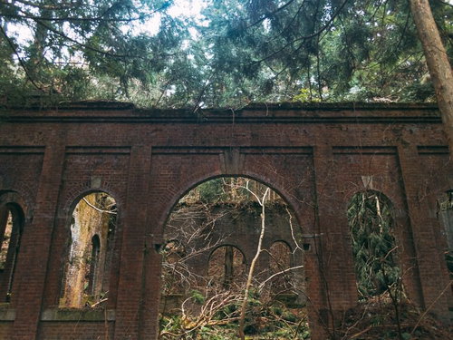 朽ちたレンガ壁が積み重なった廃発電所のアーチ開口部