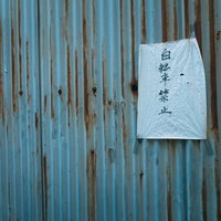 青い波板トタンに張られた自転車禁止の紙の写真