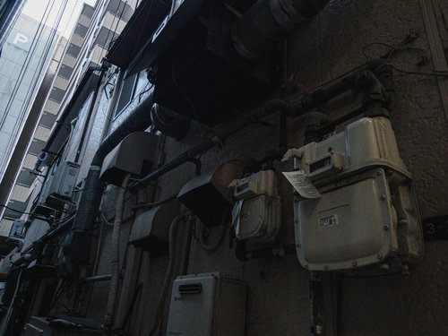 室外に設置された白いガスメーターと排気口、ダクト