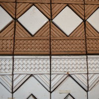 白とベージュの幾何学模様入りタイル外壁のテクスチャーの写真