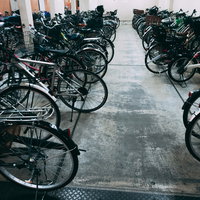 駐輪場に規則正しく整列した自転車の屋内駐輪スペースの写真