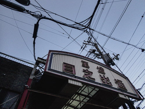 玉造日之出通商店街の路地に立つ白い看板と街並み