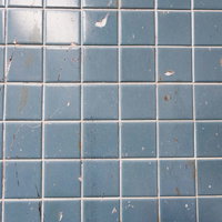 細かく傷ついた青みがかったタイル壁のテクスチャの写真