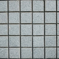 細かい粒が散るグレーの正方形タイル壁のテクスチャーの写真