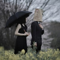 菜の花畑で黙祷する同士のふたりの写真