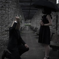 黒いドレスの女性が自分で摘んだお花を手渡して告白する場面の写真