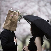 顔を隠して告白タイム、桜の下で紙袋を被った二人の写真