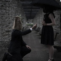 自ら摘んだお花を手渡す紙袋系男子の告白シーンの写真