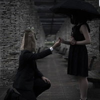 大切なお花を手渡す異色の恋、日傘を持つ女性へのプロポーズの写真