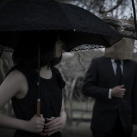 紙袋と日傘で顔を隠し女性をつき纏う予告犯の写真