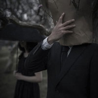 恋に敗れて頭を抱える紙袋男子の写真