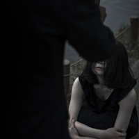 悲しみの中、突如男性の姿が傘とともに現れる瞬間の写真