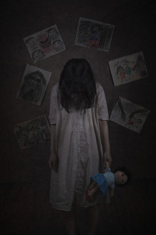 SOSと書かれた紙を持つ、ぬいぐるみに寄り添う女性