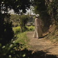 田舎に帰省して散歩する女性の後ろ姿の写真