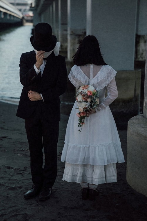 謎多き覆面の男性と白いドレスの淑女による結婚詐欺の怪しい関係