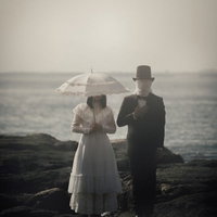 海岸で佇む正体不明のカップルのシルエットの写真