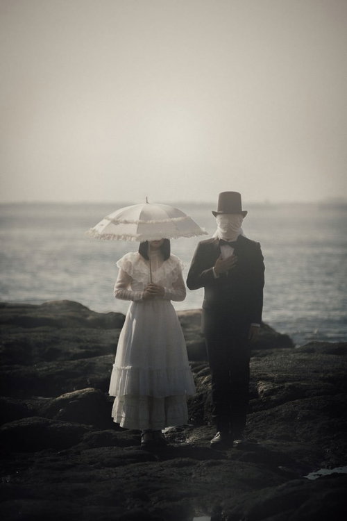 海岸で佇む正体不明のカップルのシルエット