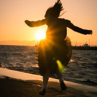 夕焼けハイテンションジャンプ、海辺で飛ぶシルエットの写真