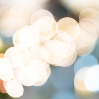 イルミネーションの連なる丸ボケ、暖色の光が輝く夜景背景の写真