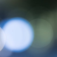 青い丸ボケ光が広がる抽象背景の写真