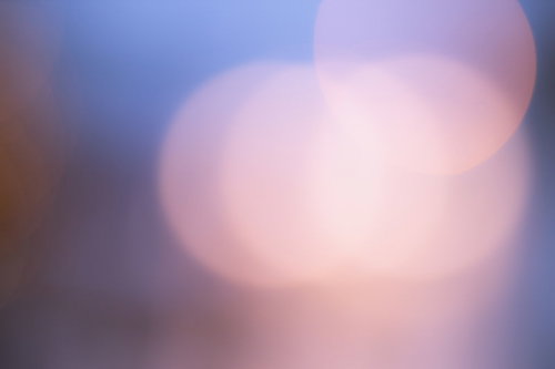 紫とオレンジの丸ボケが重なる光のグラデーション
