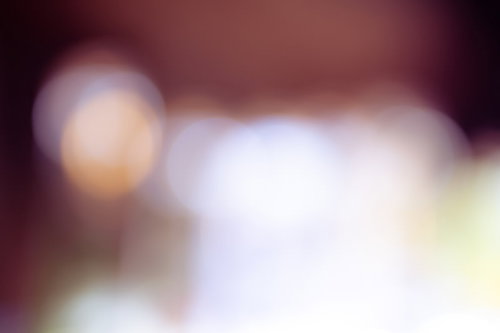 暗がりの中に浮かぶオレンジ色の丸ボケの光