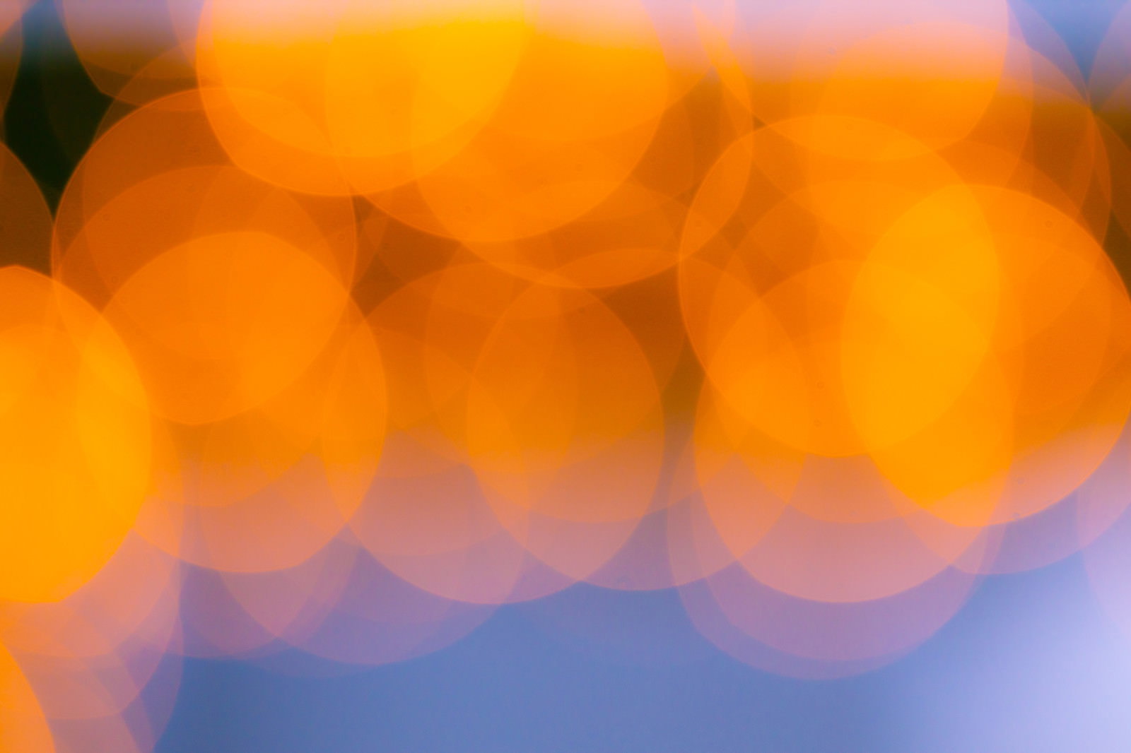 オレンジ色の暖かい光が美しくぼけた丸ボケの写真