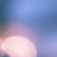 柔らかなグラデーションに重なる丸ボケの光の写真