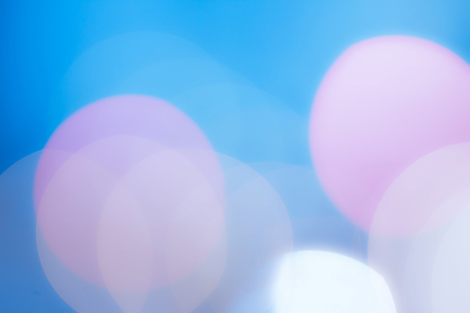 青白い寒色の丸ボケが美しい光の背景