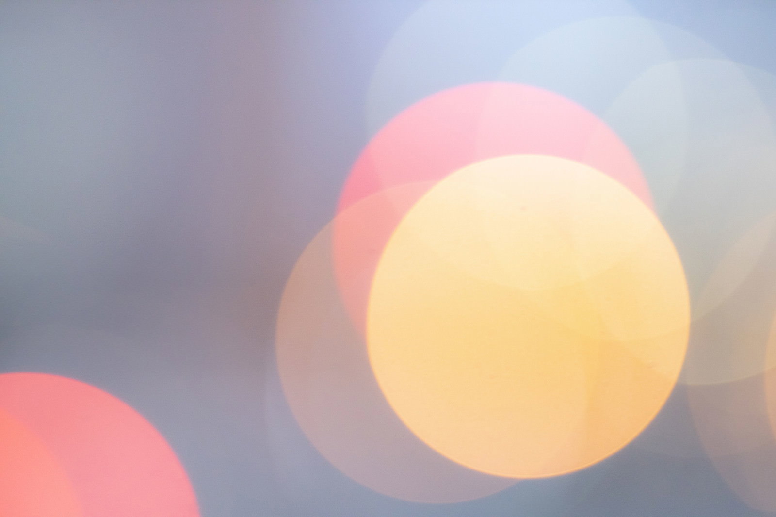 暖色系の丸いボケとキラキラした光が重なる抽象的な背景