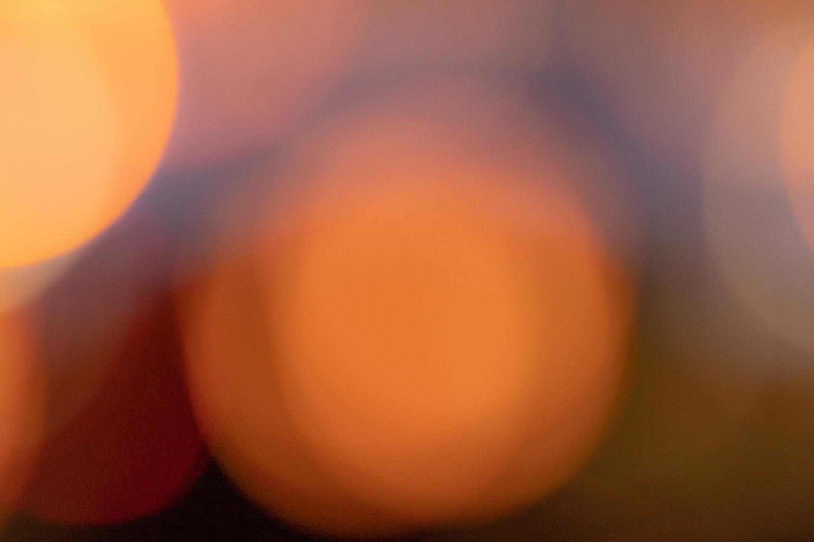 グレーの暗い空間にオレンジの丸ボケが広がる