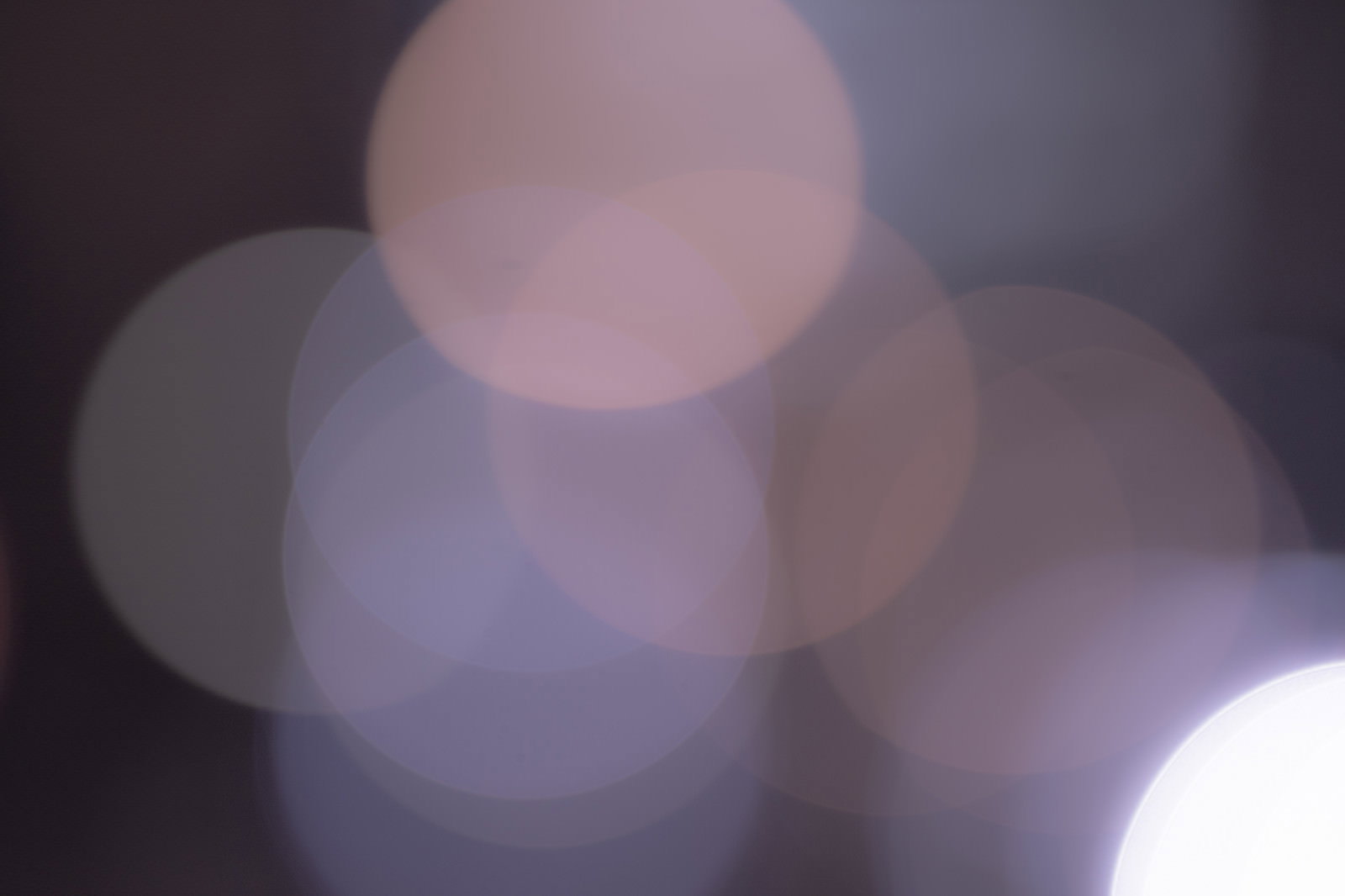 グレーを基調とした大小さまざまな丸ボケが重なり合う幻想的な光の背景